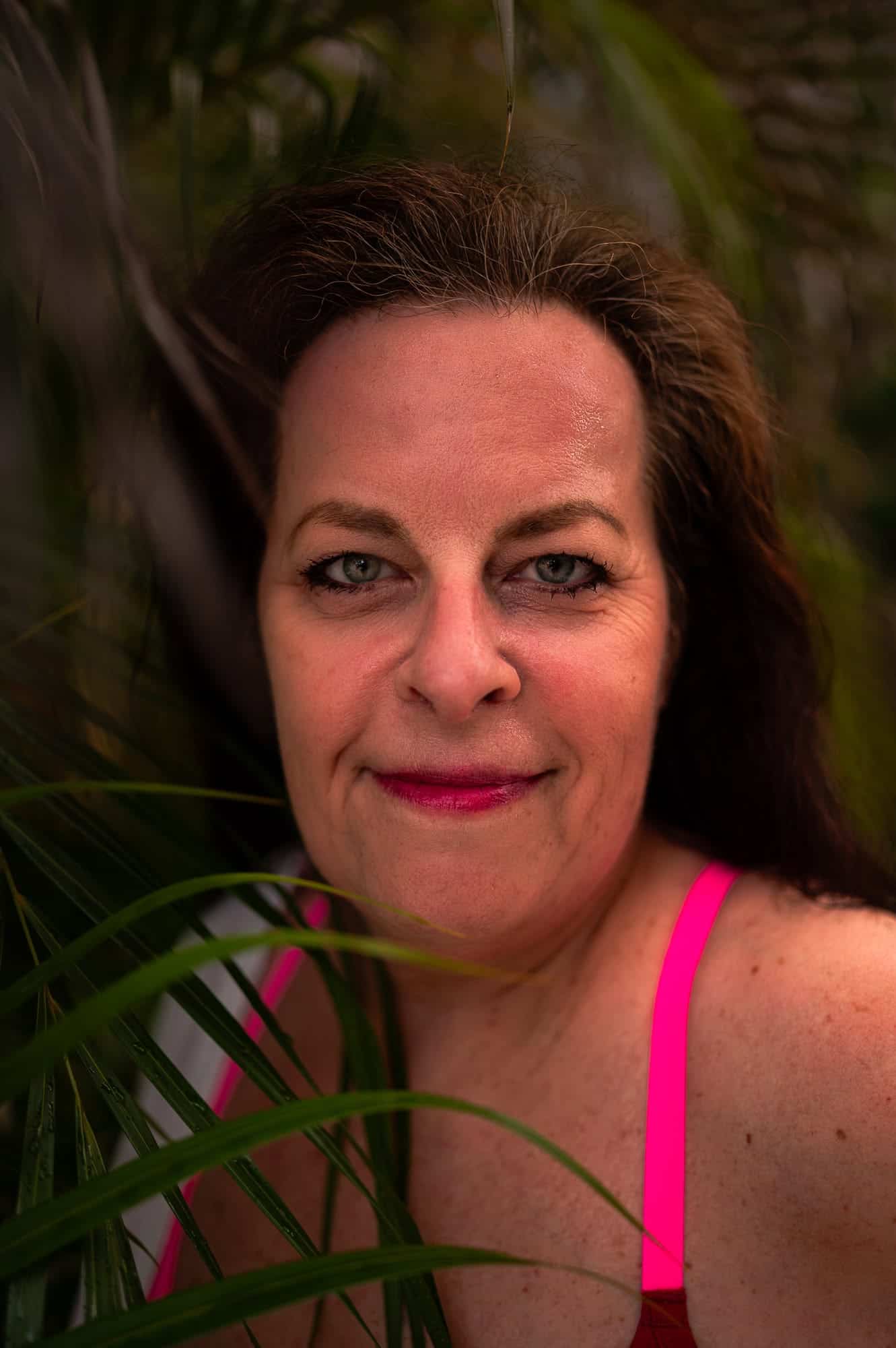 This photograph is a close up of a 60 year old woman with blue eyes. Photograph taken by a boudoir photographer. Self love can be worked on at any age. We are all deserving of a positive relationship
