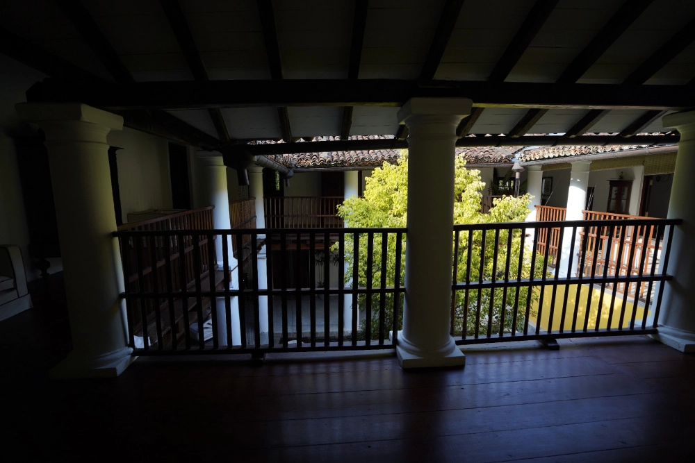 A balcony that faces the central courtyard of Adigar's manor, highlighting its rustic charm.