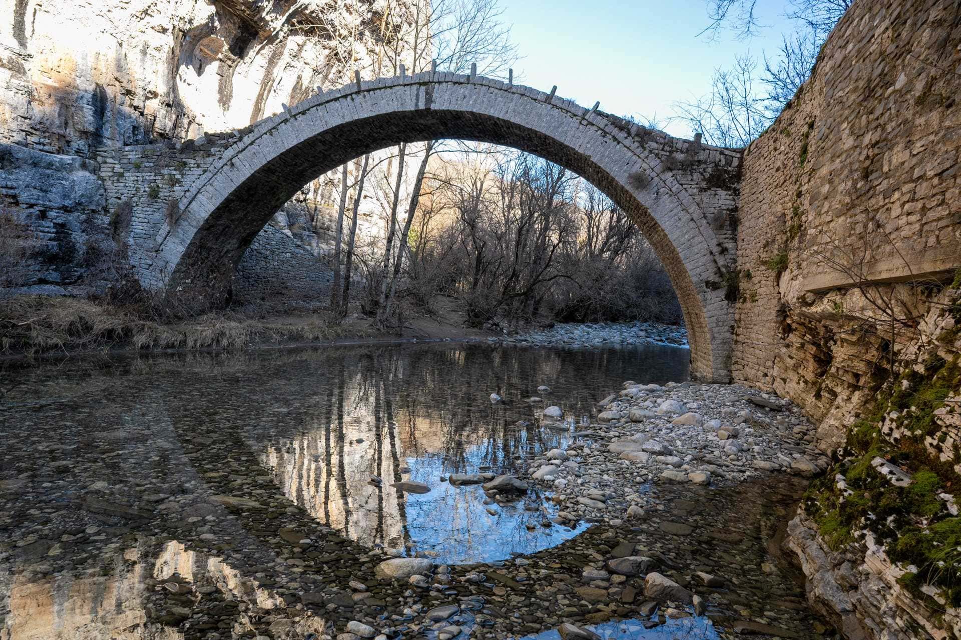 Alte Steinbrücke mit Spiegelung im klarem Fluss - Griechenland Rundreise Alte Steinbrücke mit Spiegelung im klarem Fluss - Griechenland Rundreise