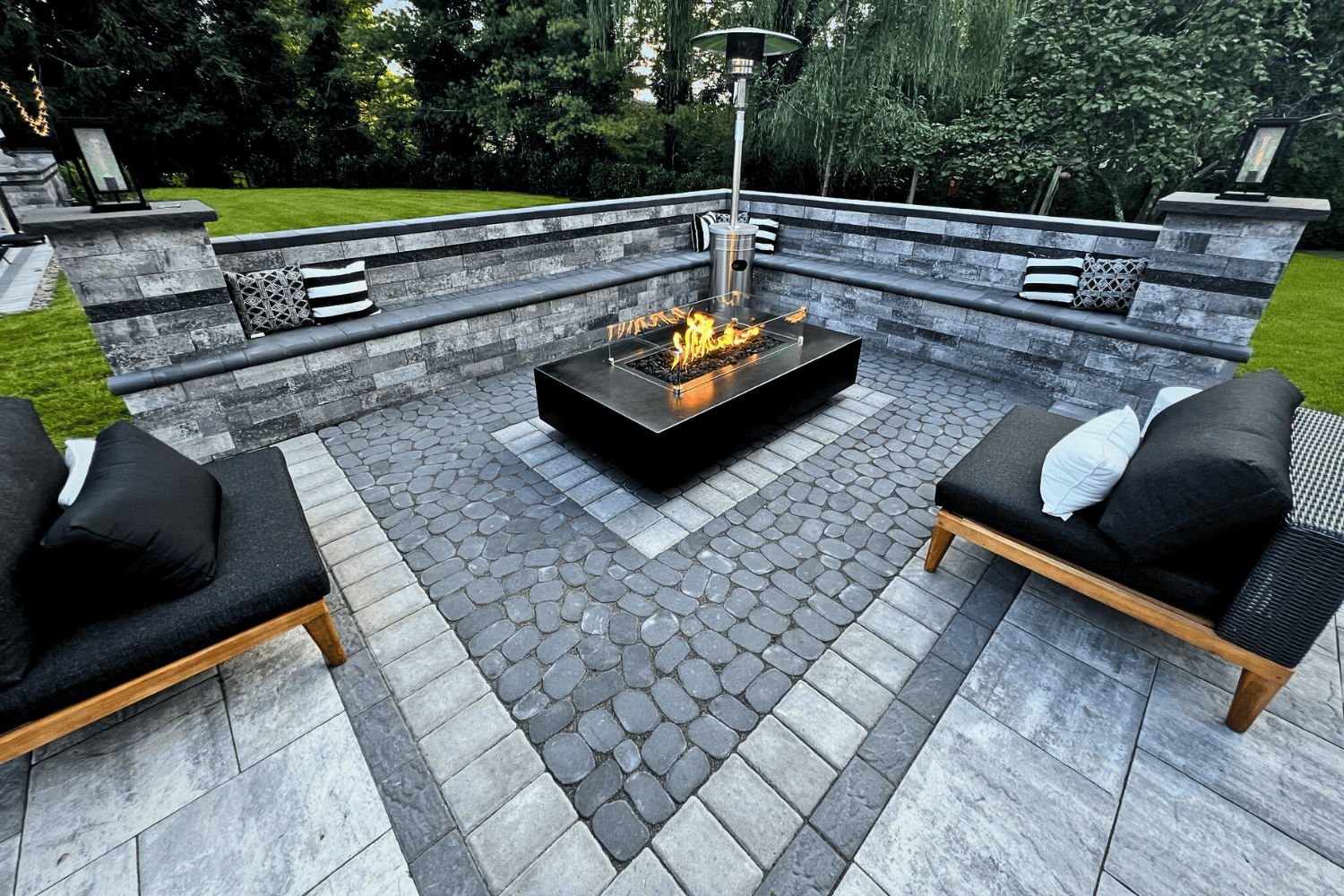 A stylish fire pit on a patio creates a cozy atmosphere, blending the natural elements of fire & water for a truly relaxing outdoor experience.