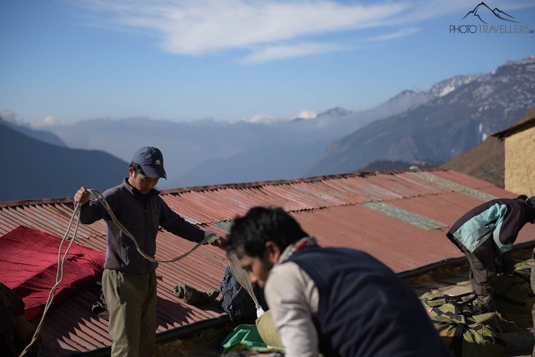 Zwei Porter in Nepal, die Gepäck zusammenbinden