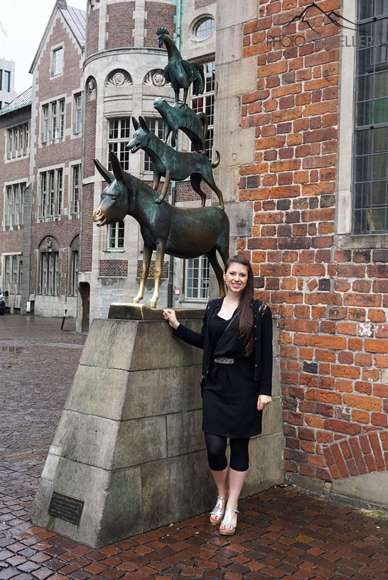 Reisejournalistin Biggi Bauer vor der Statue der Bremer Stadtmusikanten in Bremen