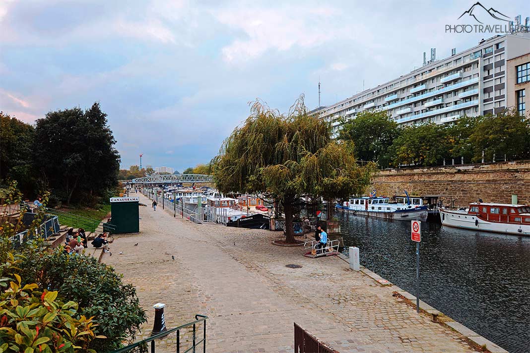 Grünanlagen und Spazierwege flankieren den Canal Saint Martin, auf dem sich kleine Hausboot aneinanderreihen