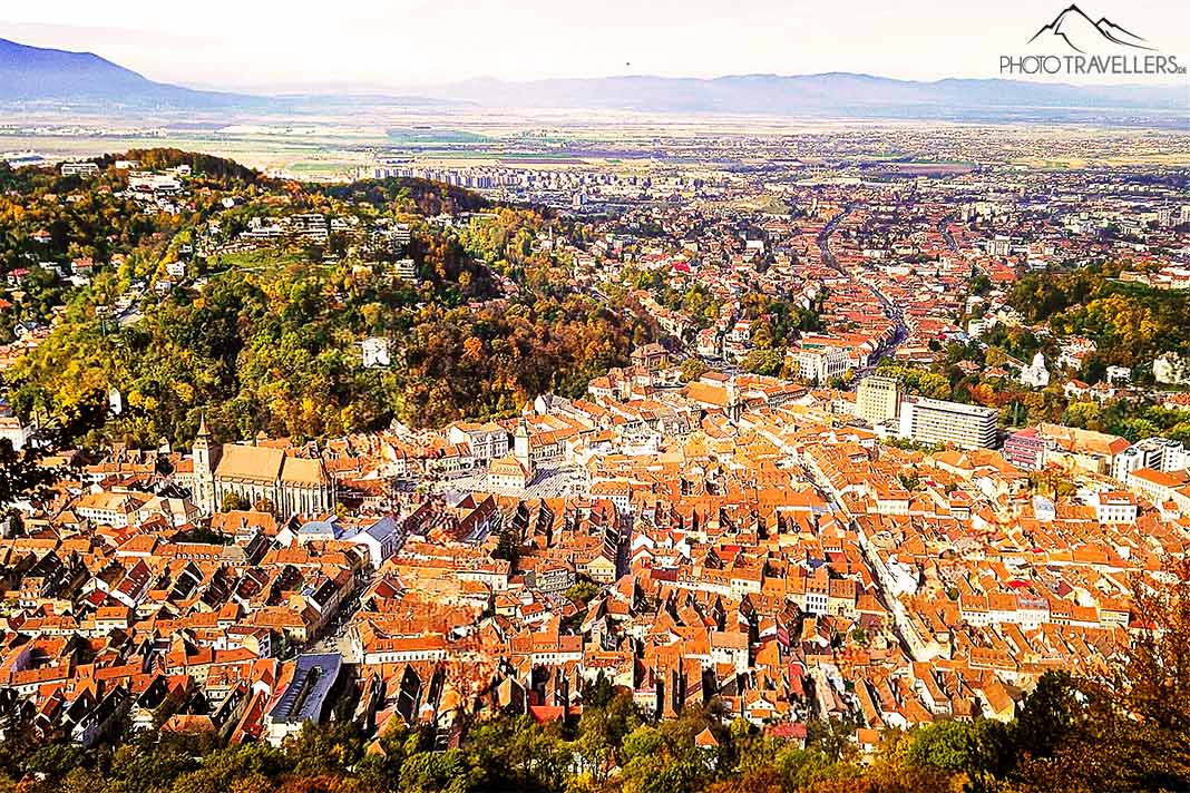 Die Stadt Brasov von oben mit den roten Dächern eingebettet in grüne Hügel
