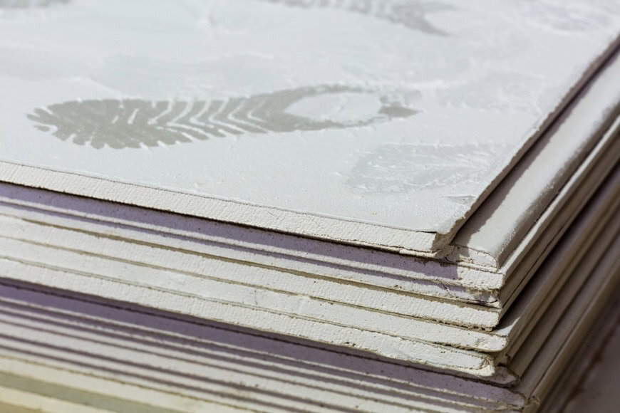 Footprints from workers shoes on the dust from construction on the sheets of plasterboard (drywall) in room is under construction, remodeling, renovation, extension, restoration and reconstruction