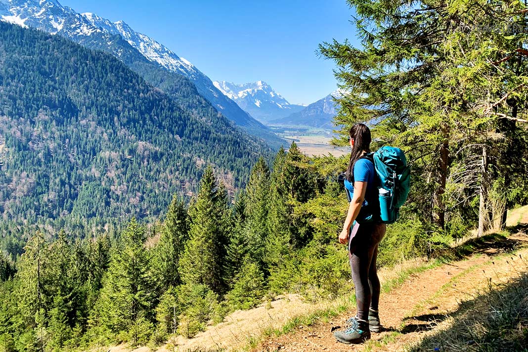 Reisebloggerin Biggi Bauer blickt von einem Wanderweg ins Loisachtal