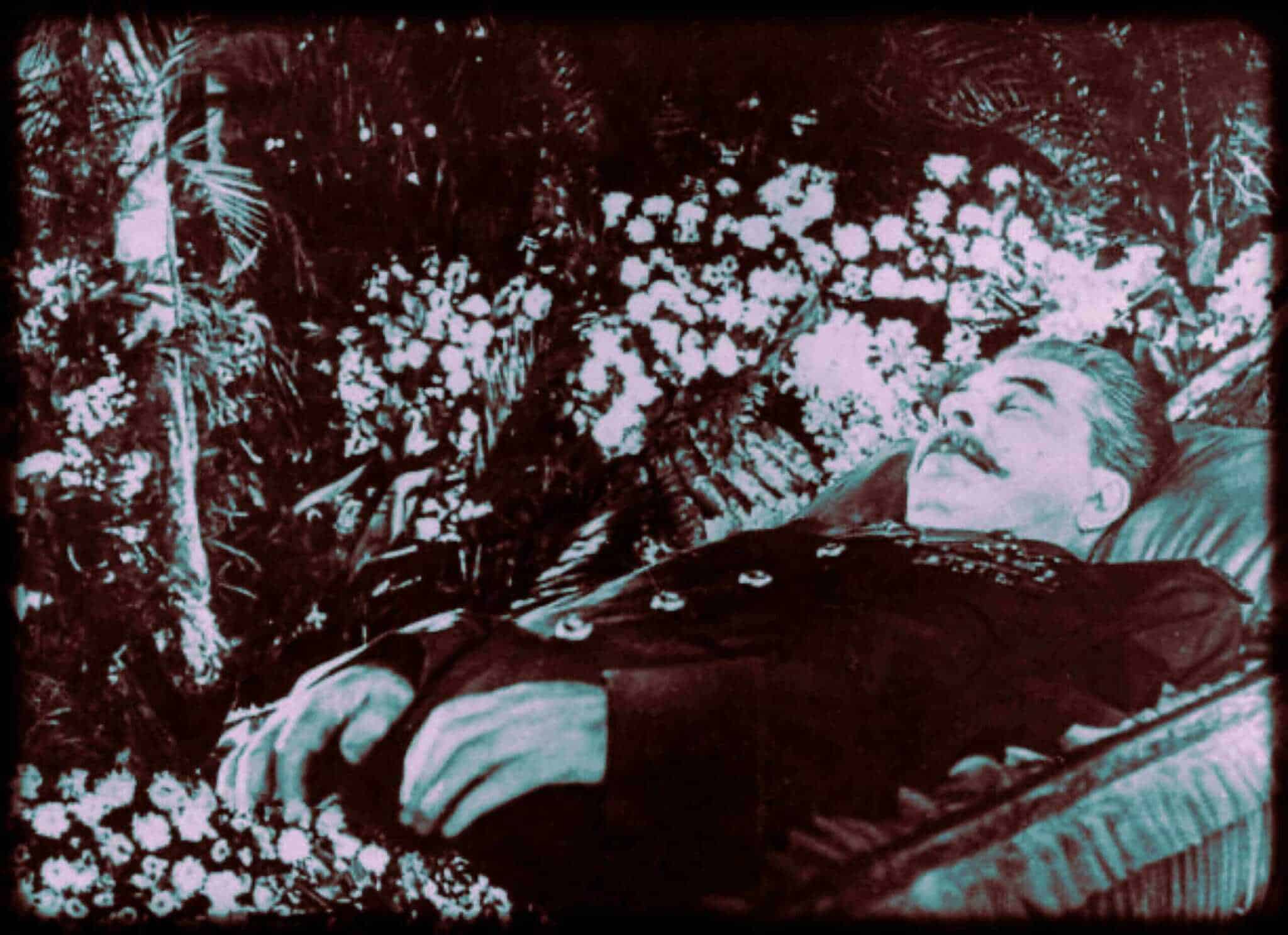 Historic photo of Joseph Stalin lying in state surrounded by flowers.
