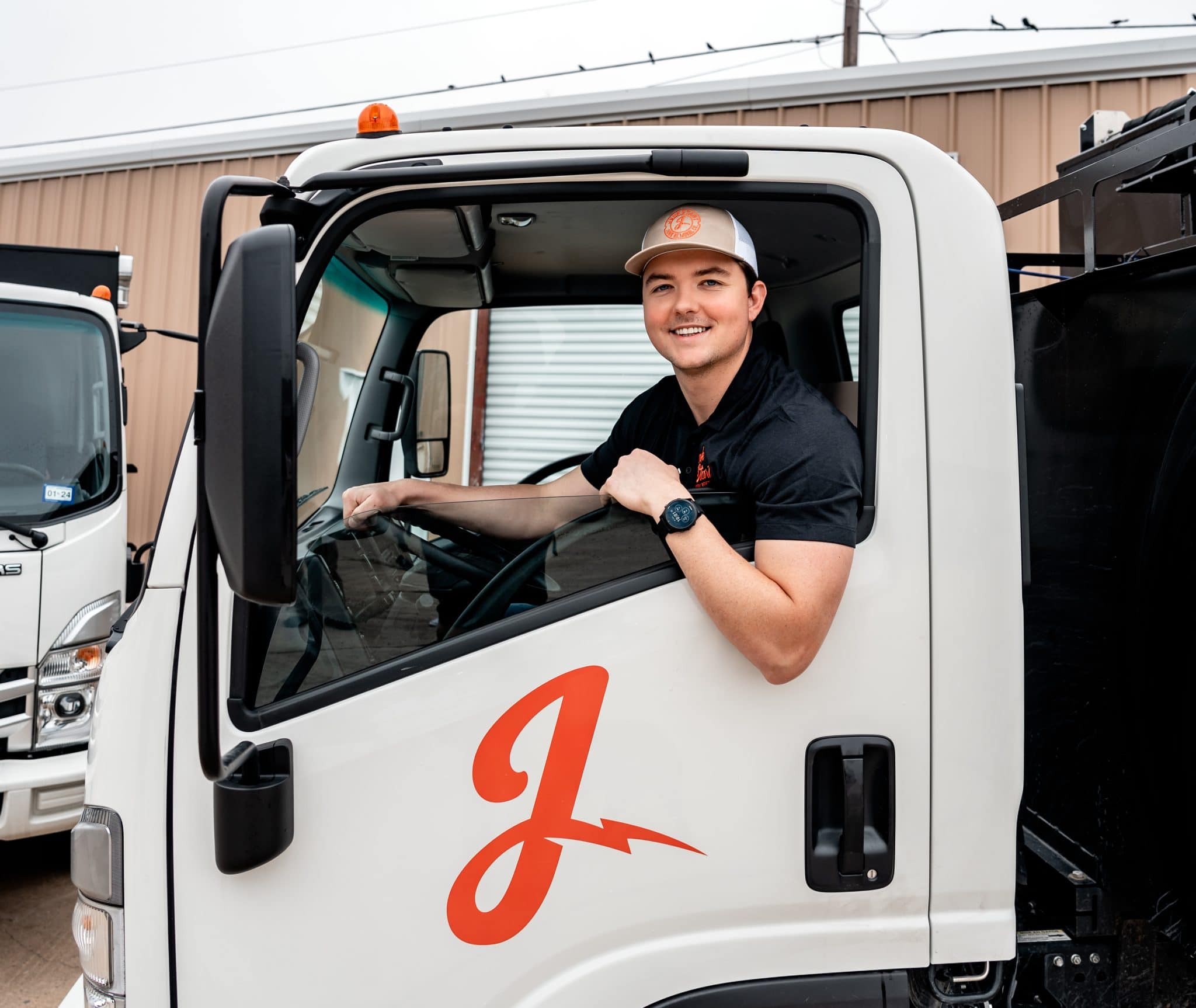 Daniel McCarty, founder of JunkStart Junk Removal, smiling from the driver’s seat of a branded company truck.