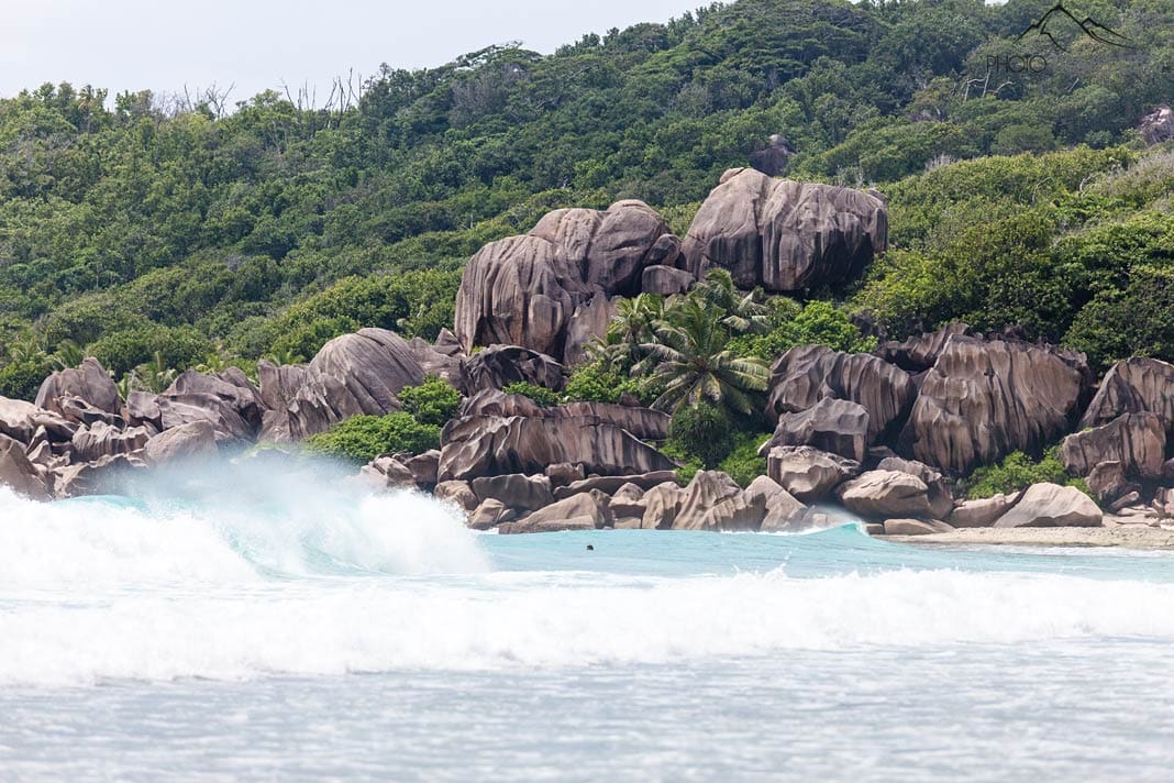 Große Wellen vor den Granitblöcken am Strand Grand Anse auf La Digue