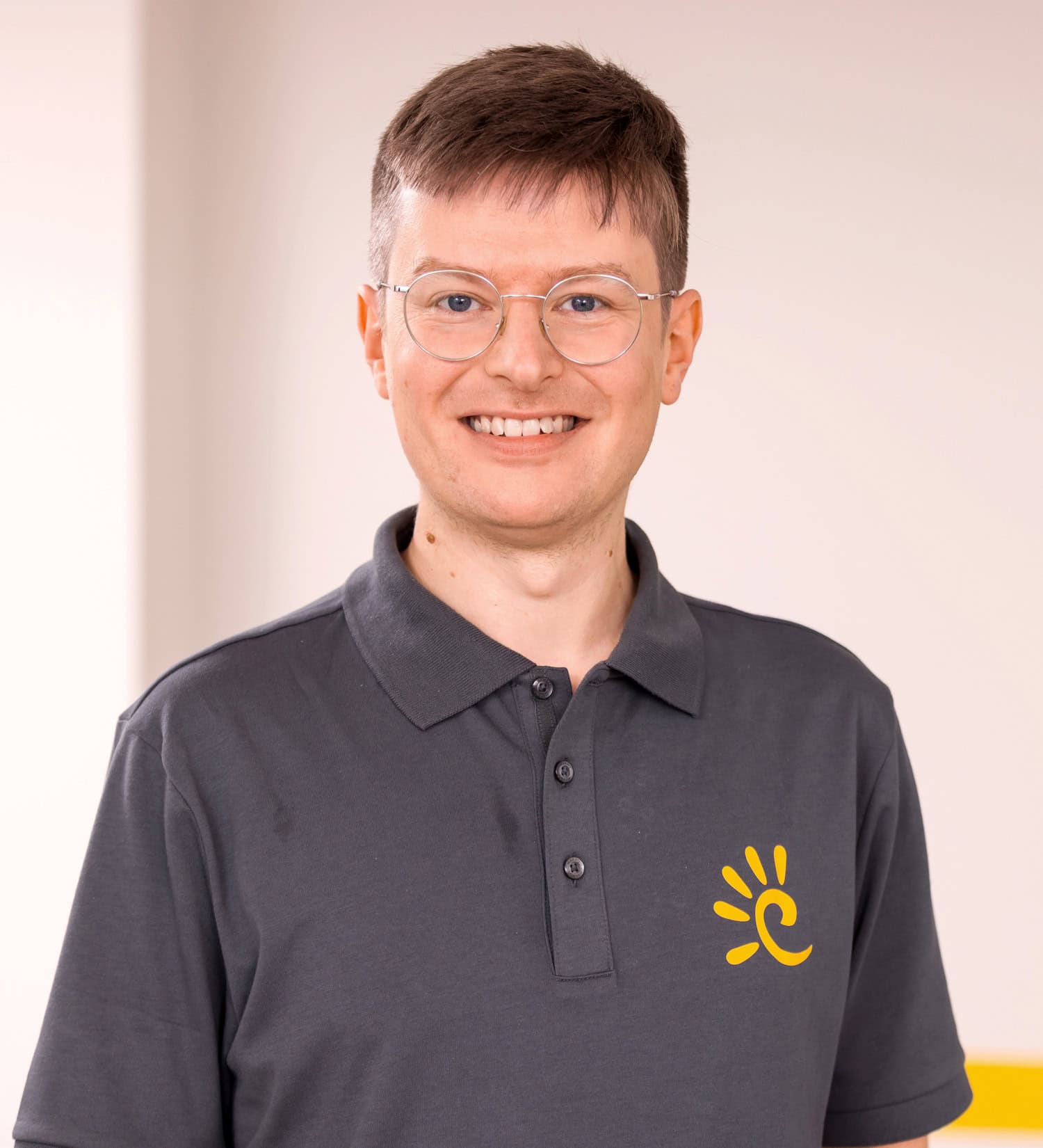 Arzt mit Brille lächelt in die Kamera.
