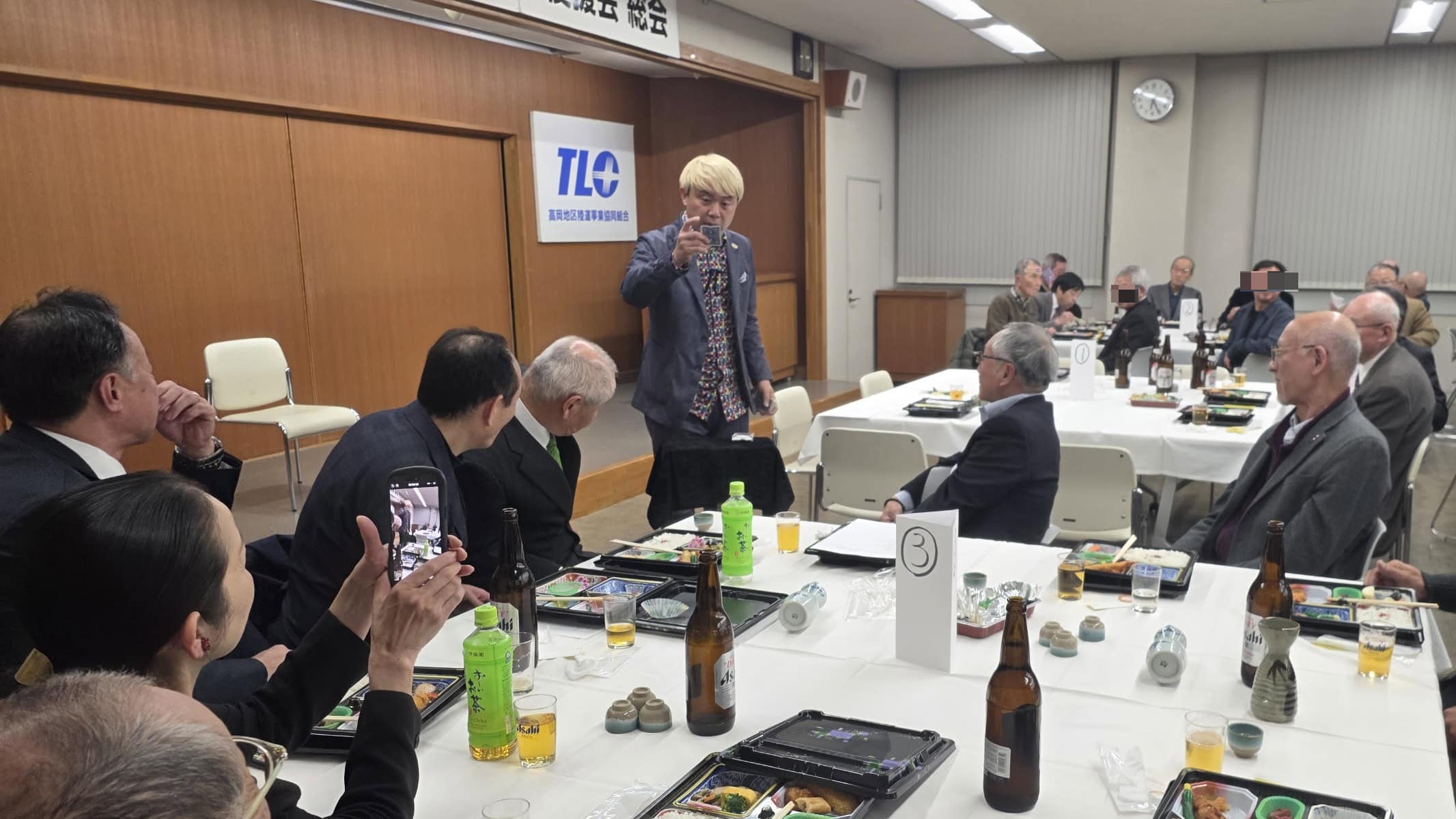 射水市テルシのパーティーでマジックショー! 4 テーブルを回ってマジックを披露するコンプレッサー。お客様がスマホで撮影しながら楽しんでいる