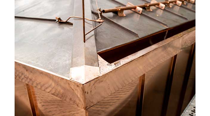 Nahaufnahme einer Metallecke mit sichtbaren Schweißnähten und Metallwerkzeugen auf der Oberfläche.