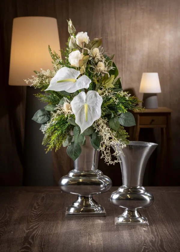 Vista frontale di un mazzo di fiori artificiali finti per cimitero e loculo - un elegante arrangiamento floreale bianco e verde, con anthurium bianchi al centro e fogliame verde intenso