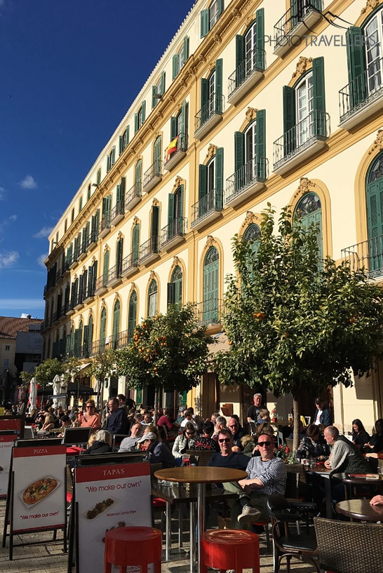 Menschen, die in der Sonne in den Cafés an der Plaza de la Merced in Málaga sitzen