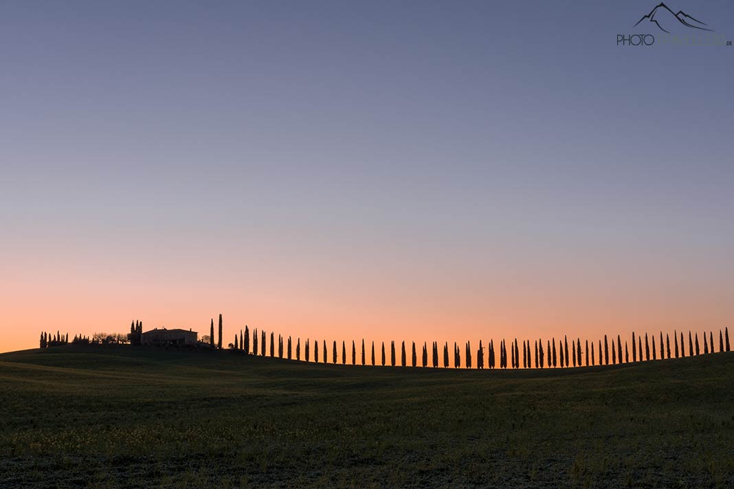 Der Blick am Morgen in der Dämmerung auf das Agriturismo Poggio Covili mit den Zypressen