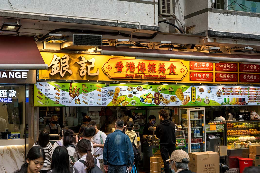 Passanten vor einem Restaurant in der Nathan Road in Hongkong