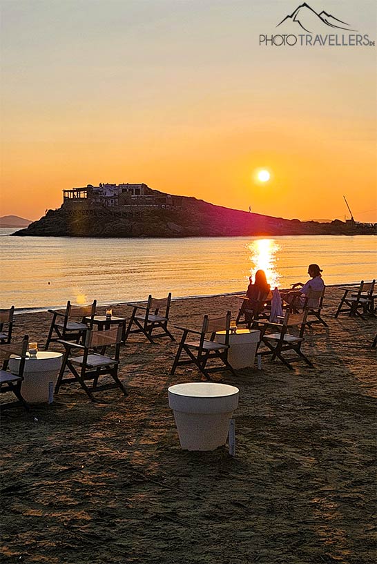 Zwei Menschen sitzen auf Stühlen beim Sonnenuntergang auf Naxos