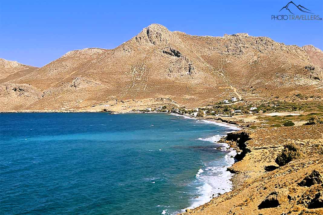 Hinter dem hellblauen Wasser der Bucht von Agios Nikolaos türmen sich hohe kahle Berge auf