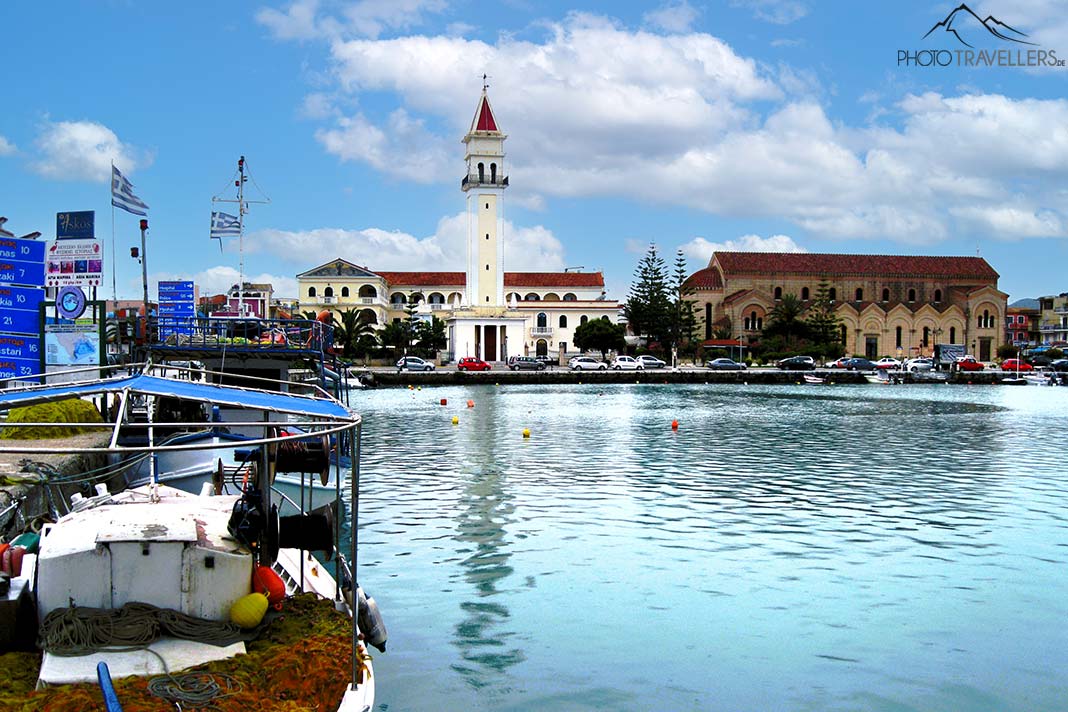 Ein Fischerboot liegt im Hafen von Zakynthos vor der Kirche des heiligen Dionysos