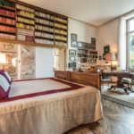 A bedroom with a bed and a large window