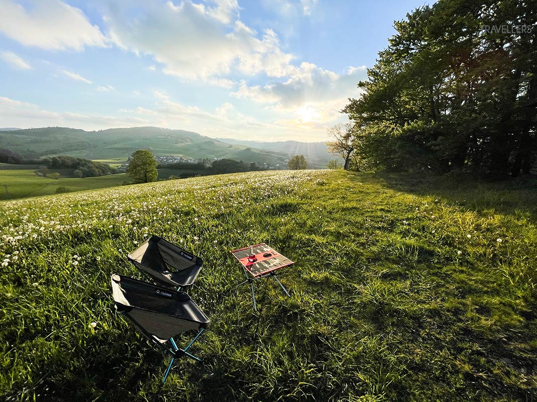 Campingstühle und Campingtisch von Helinox auf einer Wiese am Abend