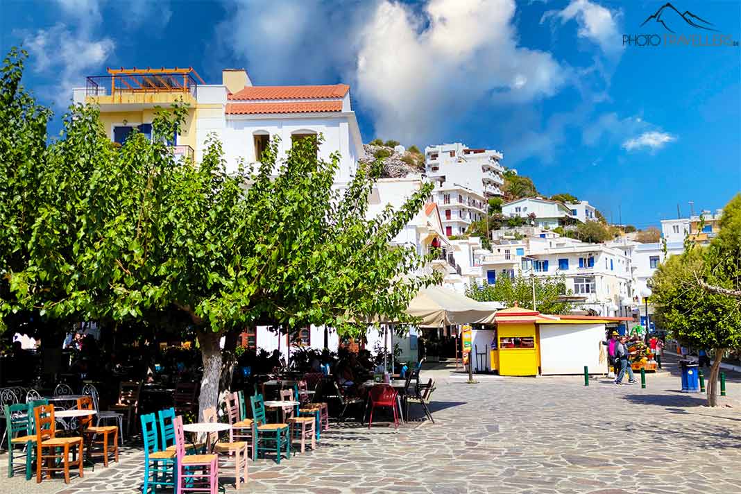 Tische und Stühle von Tavernen stehen an der Pflasterpromenade von Agios Kirykos