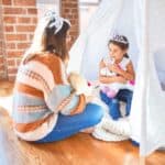 Cum să Crești Copii Inteligenți Emoțional | Lael Stone la TEDx Talks Beautiful teacher and toddler wearing princess crown playing with unicorn doll inside tipi around lots of toys at kindergarten