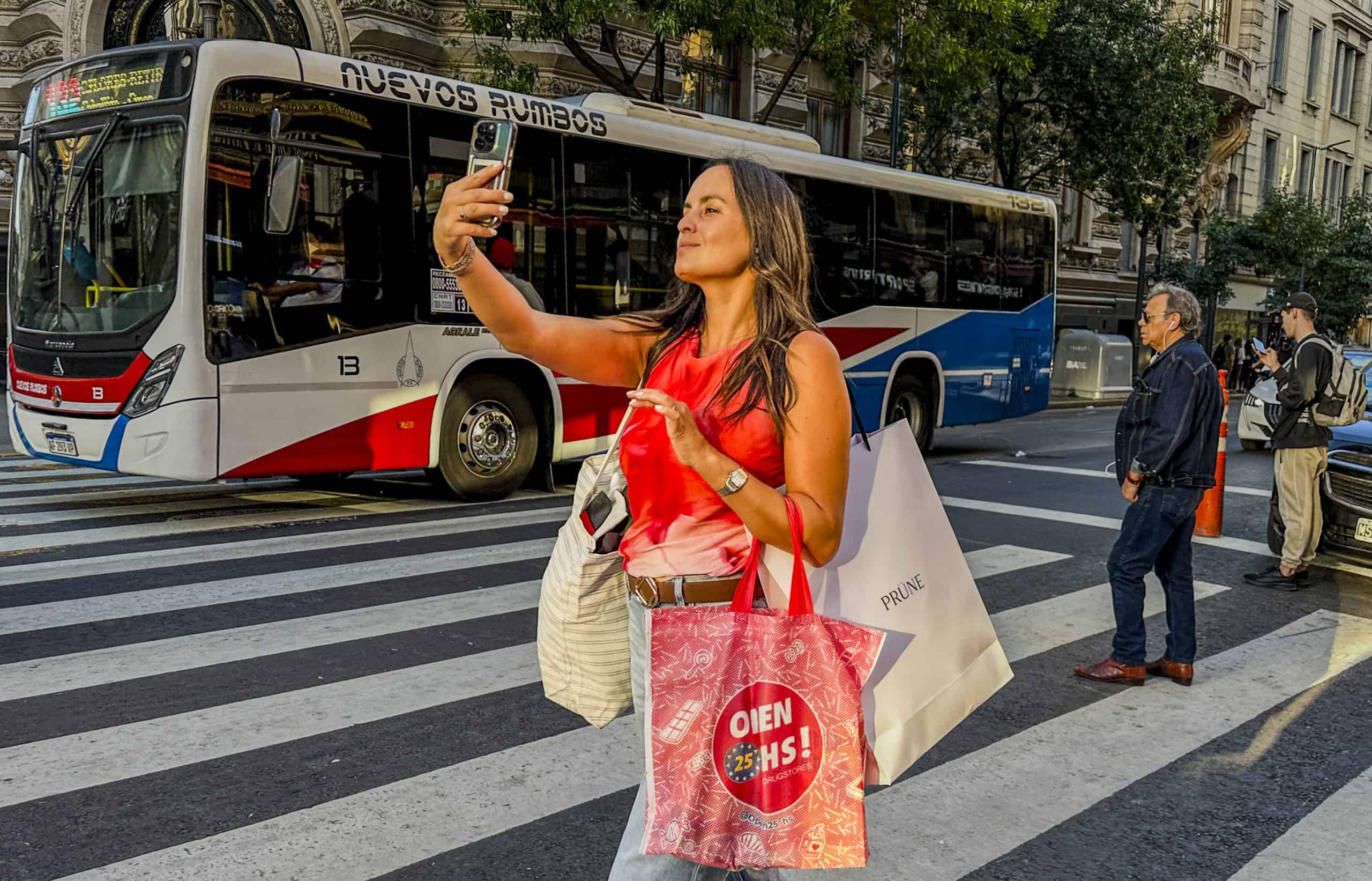 Woman taking selfie with shopping bags in Buenos Aires post-reform retail recovery