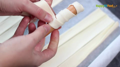 Für die Halloween Mumien Würstchen mit Blätterteigstreifen einwickeln