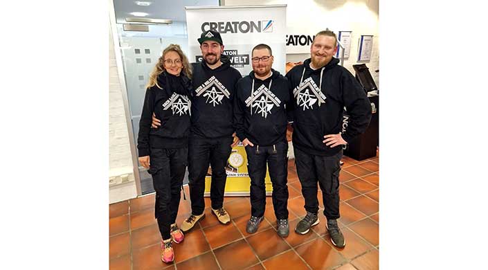 Zwei Männer stehen nebeneinander und tragen schwarze Hoodies mit weißem Aufdruck, vor einem Messestand mit dem Creaton-Logo.