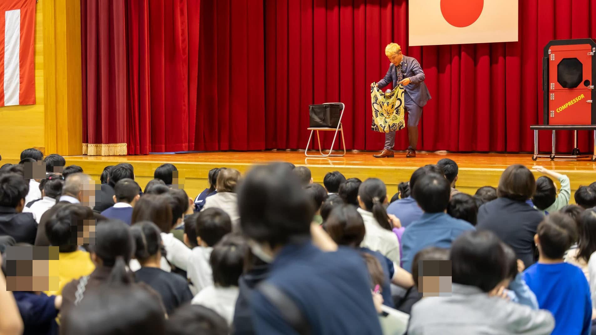 富山県立高岡支援学校 創立60周年記念講演:「思い込み」の先には「いつも通り」の笑顔 5 マジシャン・コンプレッサーが高岡支援学校のステージでゾンビボールのマジックを披露し、生徒たちが注目している。