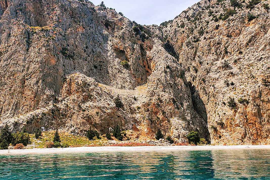 Hinter dem schmalen Kiesstreifen der Bucht von Saint George türmen sich mächtige Felslandschaften auf