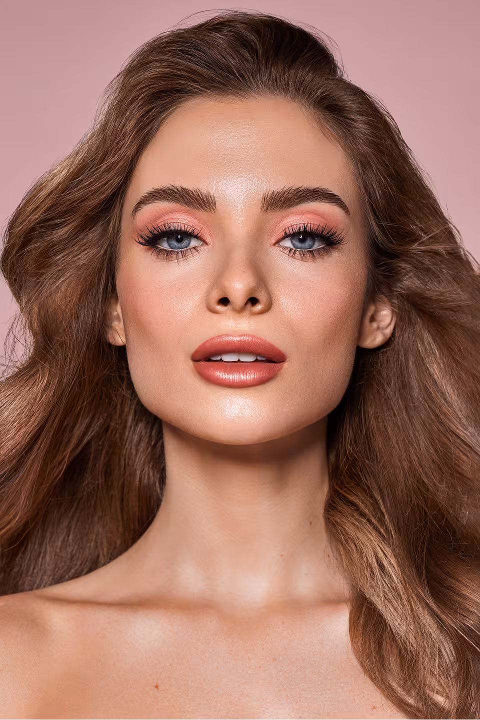 Person mit hellrosa Lidschatten und beerenfarbenem Lippenstift blickt frontal in die Kamera