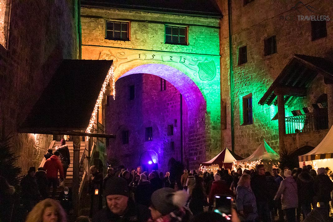 Ein beleuchtetes Tor der Burg zu Burghausen während des Weihnachtsmarktes