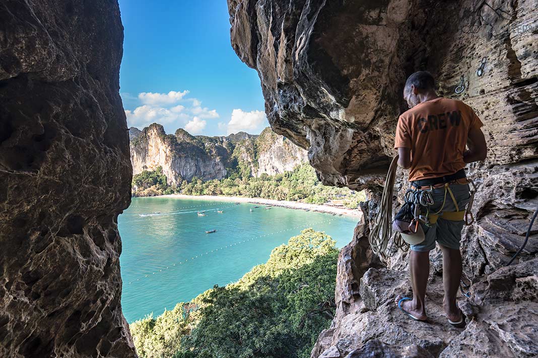 Ein Kletter-Guide in der Bat Cave mit Blick auf den Railay West Beach