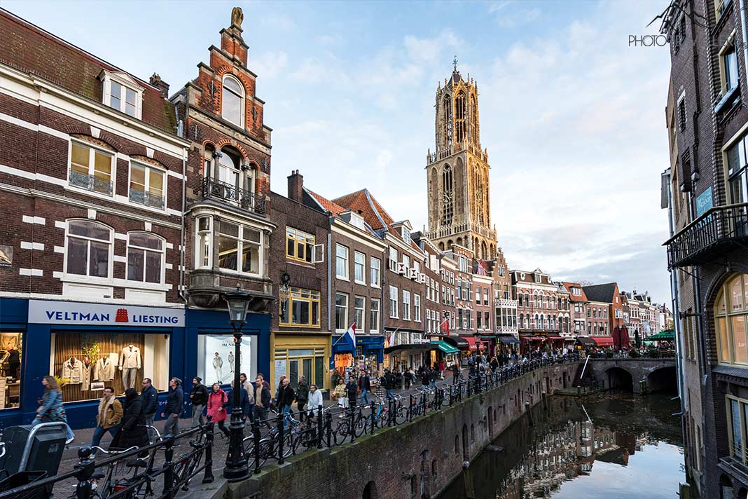 Der Turm Domtoren erhebt sich über den historischen Häusern und einer Gracht in Utrecht