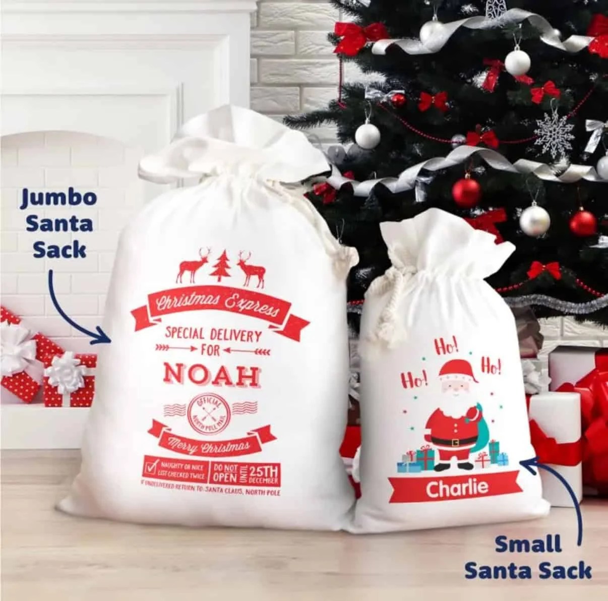 Christmas Gmones in Lights Classic T-Shirt 16 Two Santa Sacks Custom and Personalised are in front of a decorated tree: a large sack with festive red text for Noah, and a smaller sack featuring a Santa illustration for Charlie. Stockings hang by the fireplace in the background.