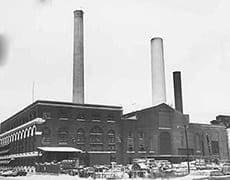 IM-PowerTMB Industrial-era brick building with tall smokestacks, historic museum exterior.