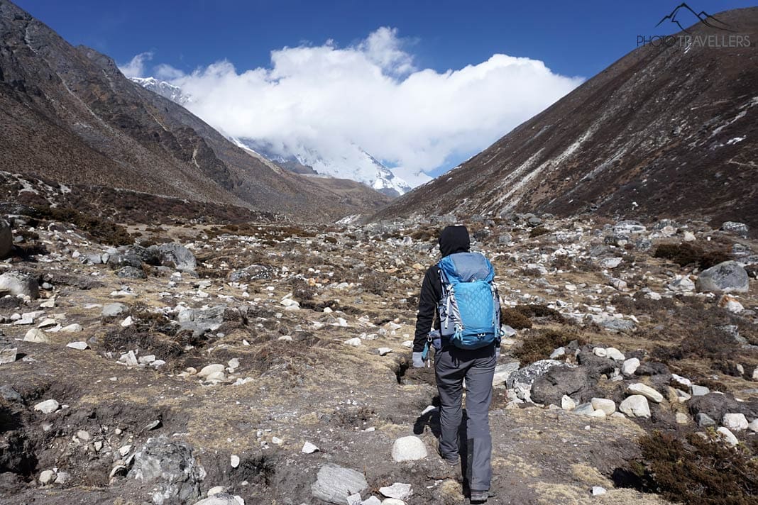 Reisebloggerin Biggi Bauer wandert zwischen hohen Bergen in Nepal und trägt einen blauen Gregory Maven