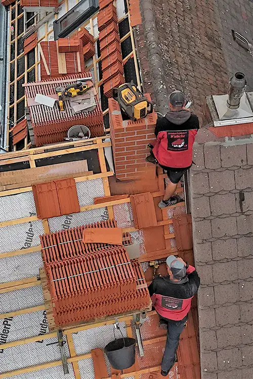 Arbeiter bauen ein Ziegeldach, stapeln Ziegelsteine und nutzen Bauwerkzeuge.