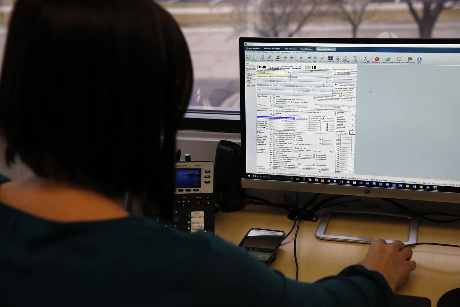 As the tax report season is underway, the interest in possible deduction is growing larger by the day. The most beneficial way to do so is by opening a retirement or health savings account. A tax expert is filling out a digital tax report.