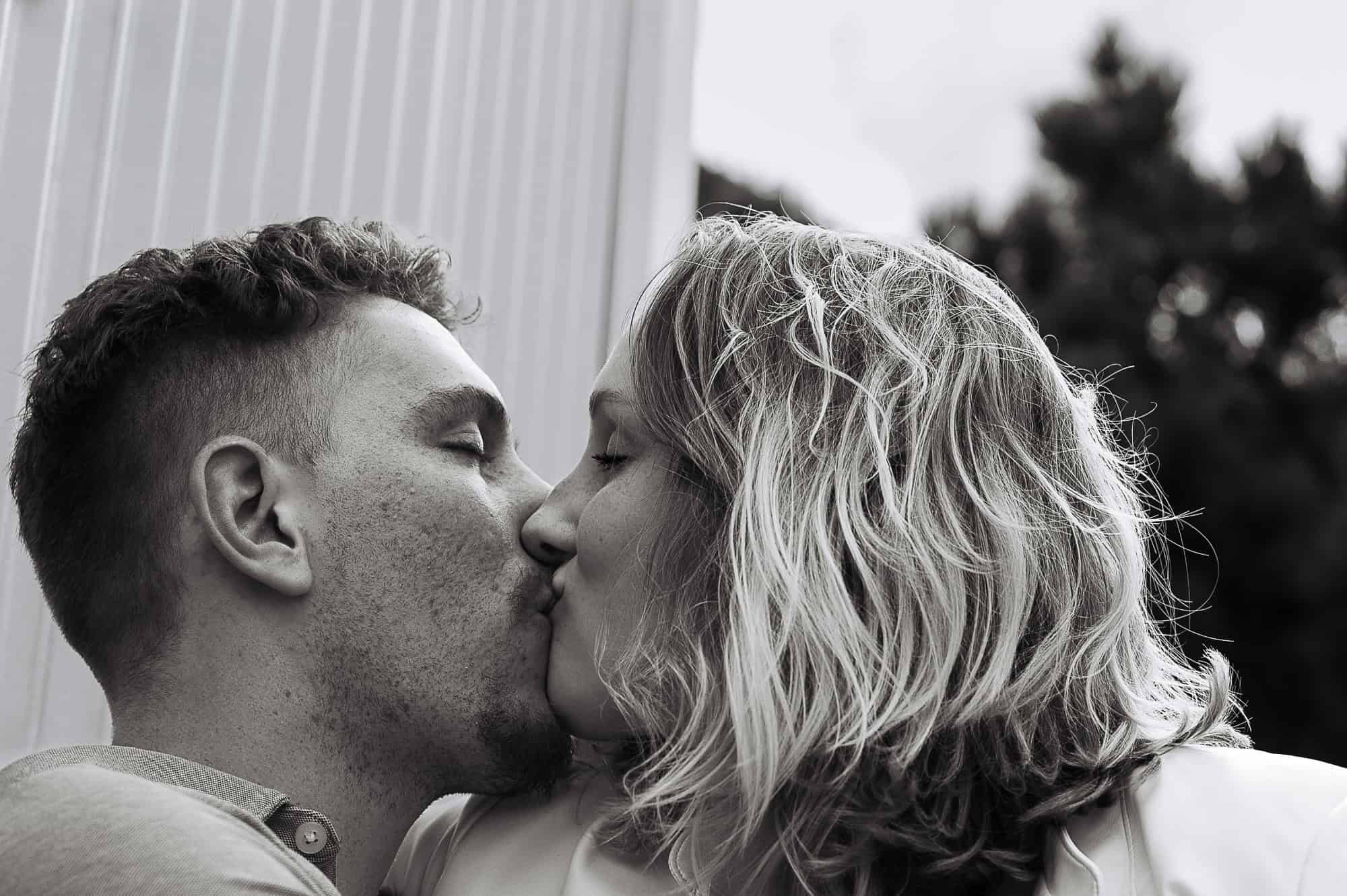 photograph from a couples boudoir photoshoot at the zoo. In this photograph the couple is kissing.