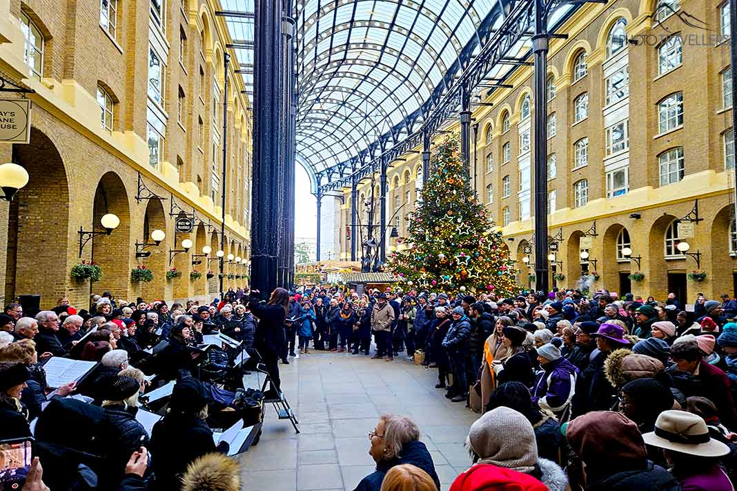 Eine große Gruppe von Menschen lauscht einem Weihnachtschor in der Hays Galleria