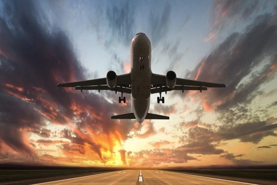 Plane jetting off the runway with a sunrise