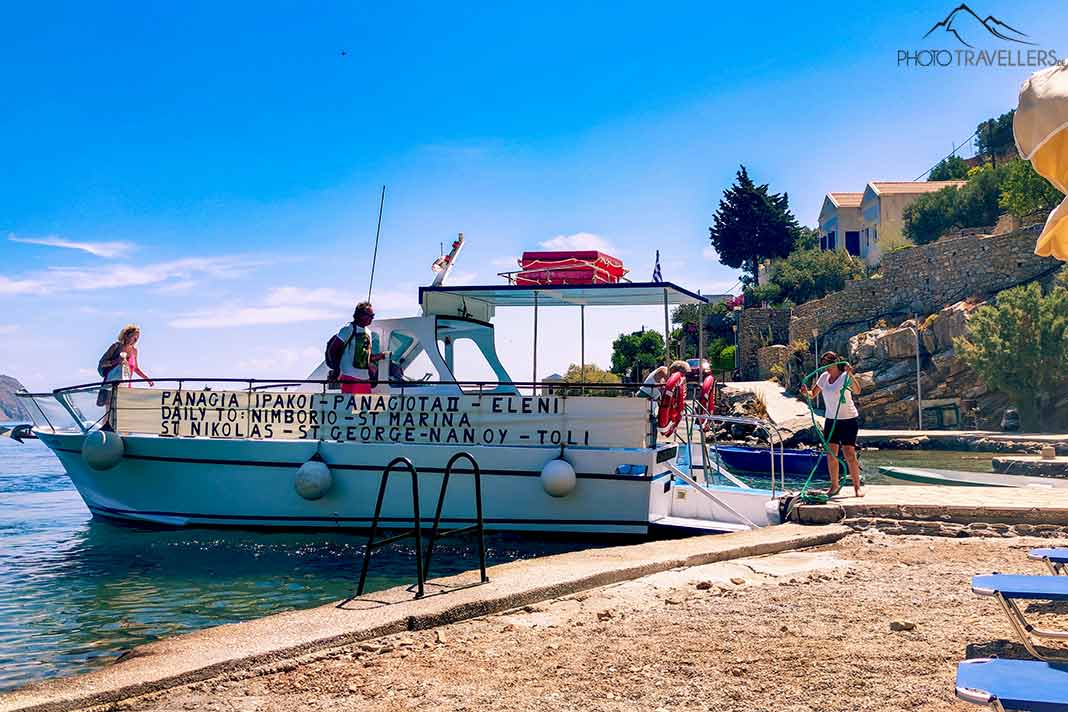 Eine Yacht bringt mehrere Badegäste an den Strand von Symi