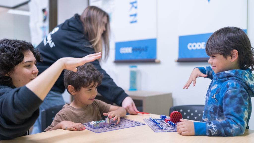 Kids work hands-on with snap circuit kits inside a Code Ninjas dojo. Image Courtesy of Code Ninjas.