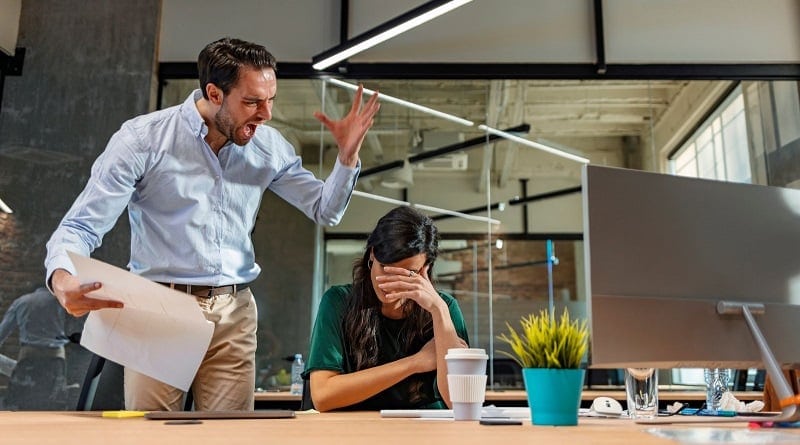 Hostile Work Environment / Male employee shouting at a distressed woman in a green dress