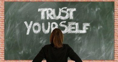 Woman standing in front of chalkboard on brink wall - Boost Your Self Confidence