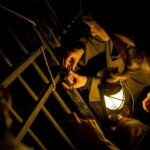 Chaîne en métal et activités de camping nocturnes dans une ambiance sombre.