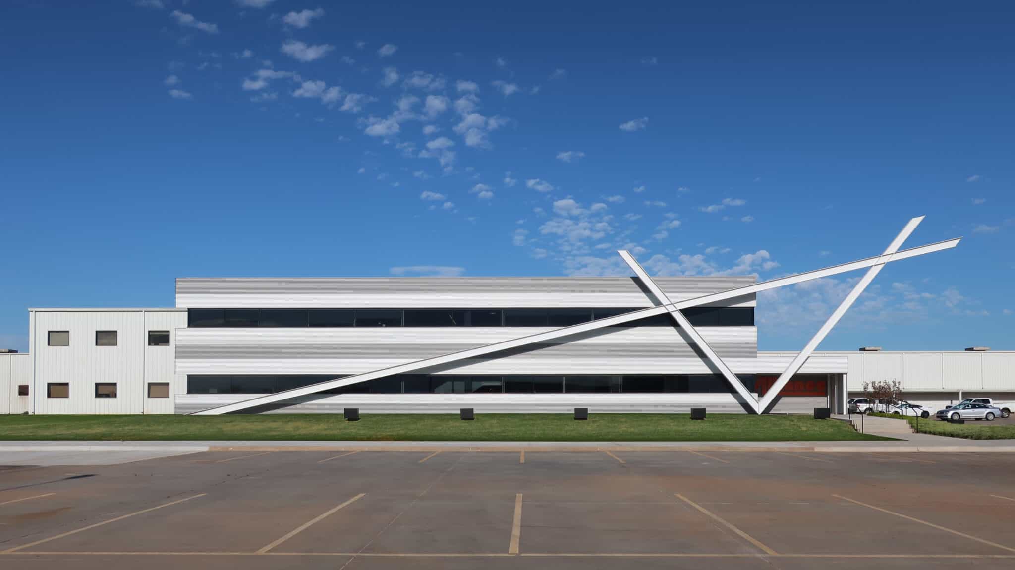 Exterior view of Alliance Steel building with striking angular architectural design under a clear blue sky.